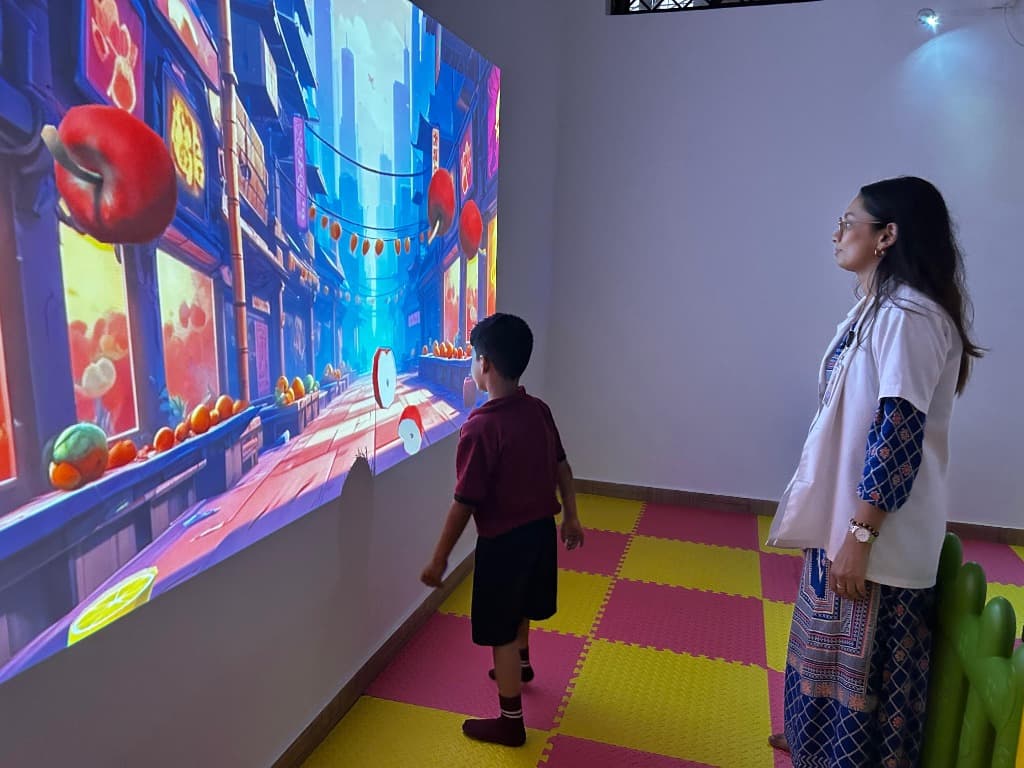 A student using an interactive learning wall at Jyothis Special School